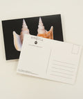 Postcard with shell design on a wooden surface