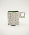 Speckled ceramic mug on a wooden surface 