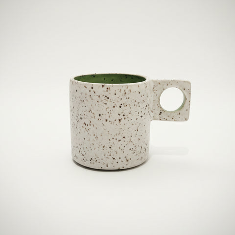 Speckled ceramic mug on a wooden surface 