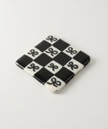 Black and white checkered coaster on a wooden surface