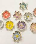 Decorative flower-shaped ring dishes on a wooden surface