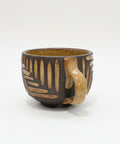Ceramic cup with decorative patterns on a wooden surface.