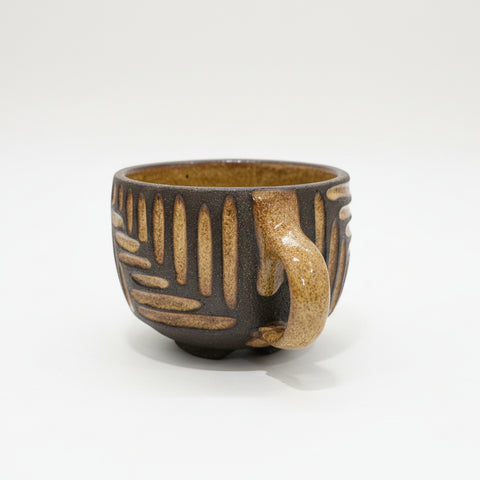 Ceramic cup with decorative patterns on a wooden surface.