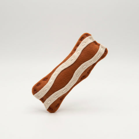 Catnip toy in clear packaging with a label on a textured fabric background