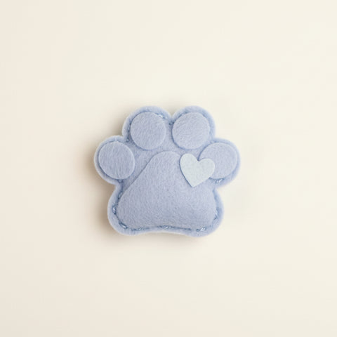 Catnip toy packaging with paw design on a textured surface