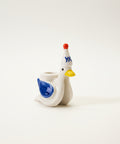 Small figurine of a bird with a colorful party hat.
