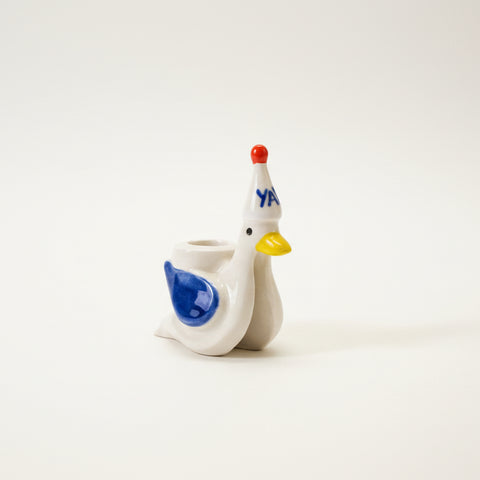 Small figurine of a bird with a colorful party hat.