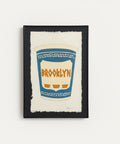 Framed artwork of a blue and white cup with 'Brooklyn' text.