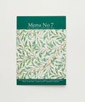 Menu No 7 with green leaf pattern on a wooden surface