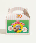 DIY crochet kit packaging with cartoon character on a wooden surface