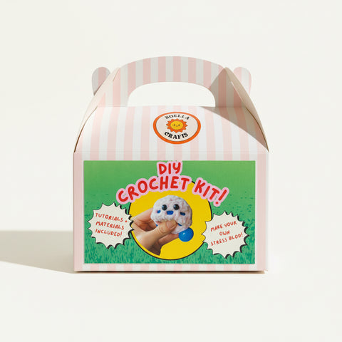 DIY crochet kit packaging with cartoon character on a wooden surface