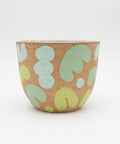 Ceramic planter pot with a green abstract design