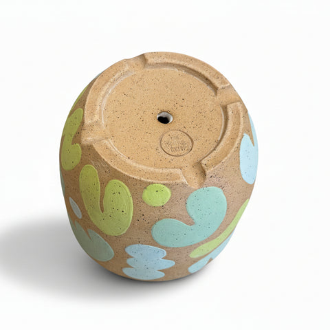 The bottom of a ceramic planter pot with a drainage hole.