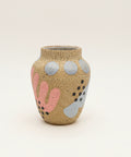 Decorative vase with polka dot pattern on a wooden desk