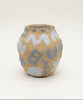 Ceramic vase with abstract patterns on a wooden surface