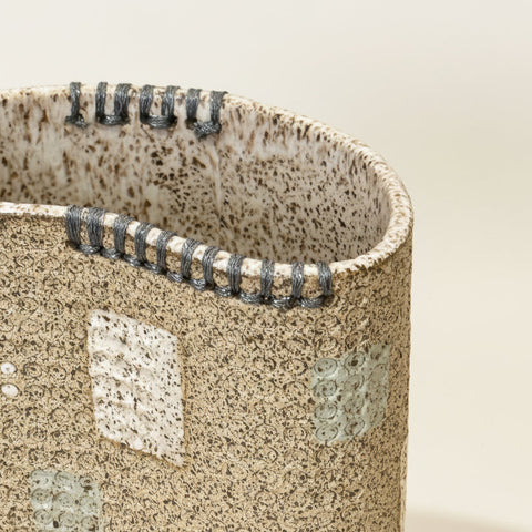 Close-up of a textured ceramic vase with speckled pattern.