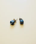 Dice-shaped earrings on a wooden surface