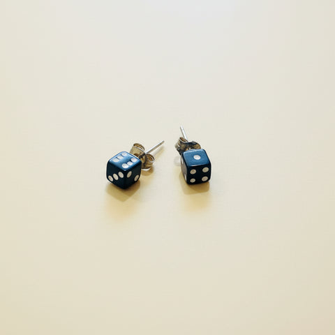 Dice-shaped earrings on a wooden surface