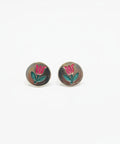 Silver earrings with floral design on a wooden surface