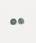 Silver floral earrings on a wooden surface