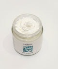 Jar of white cream with 'Yahlistic' label on a wooden surface