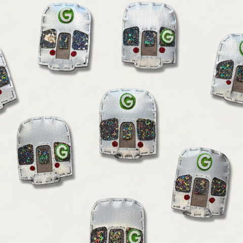 Multiple small refrigerator magnets shaped like the Brooklyn 'G' Train