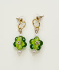 Pair of green floral earrings on a wooden surface