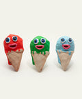 Three colorful ice cream cone toys on a wooden surface