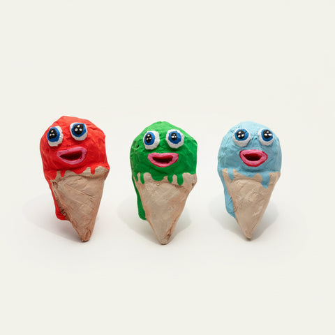 Three colorful ice cream cone toys on a wooden surface