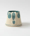 Ceramic cup with leaf design on a wooden desk