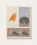 Illustrated print with a bird, tree, and flowers on a wooden surface