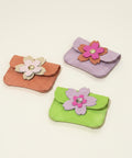 Three small pouches with floral designs on a wooden surface