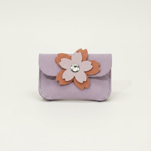 Small purple pouch with a floral design on a wooden surface