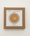 Card with a waffle design on a wooden surface
