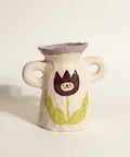 Small ceramic vase with a decorative design on a white surface