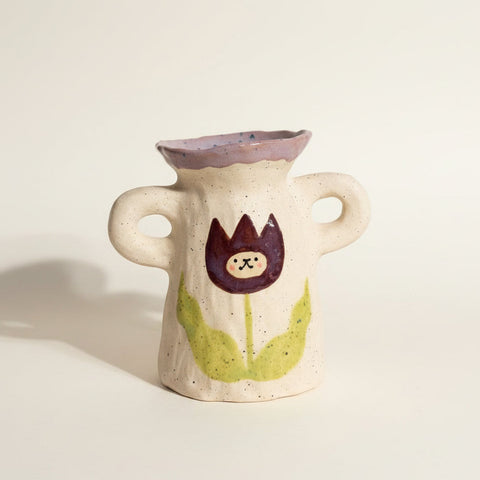 Small ceramic vase with a decorative design on a white surface