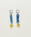 Pair of earrings with blue braided design and yellow star-shaped charms on a white background