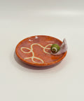 Small ceramic dish with floral design on a wooden surface