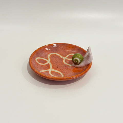 Small ceramic dish with floral design on a wooden surface