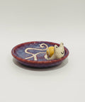 Ceramic dish with a small figurine on a wooden table