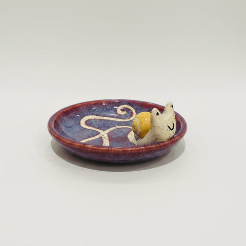 Ceramic dish with a small figurine on a wooden table