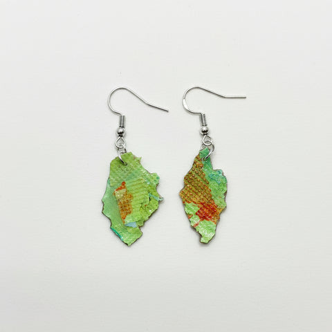 Pair of green earrings on a wooden surface