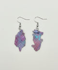 Pair of pink and purple earrings on a wooden surface