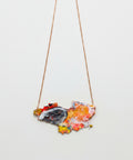 Necklace with a colorful pendant on a wooden surface