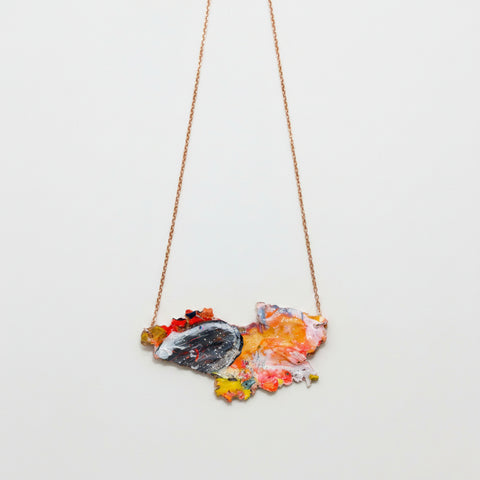 Necklace with a colorful pendant on a wooden surface