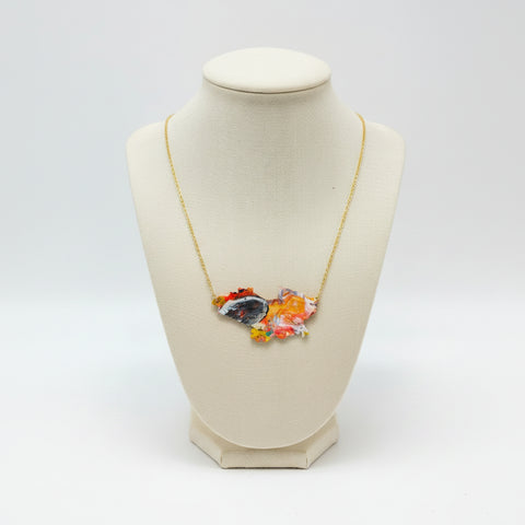 Necklace with a colorful pendant on a wooden surface