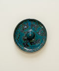 Ceramic dish with blue and black glaze on a wooden surface