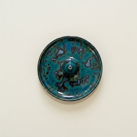 Ceramic dish with blue and black glaze on a wooden surface