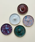 Five ceramic incense burners with different designs on a wooden surface