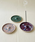 Three ceramic incense burners with speckled patterns on a wooden surface